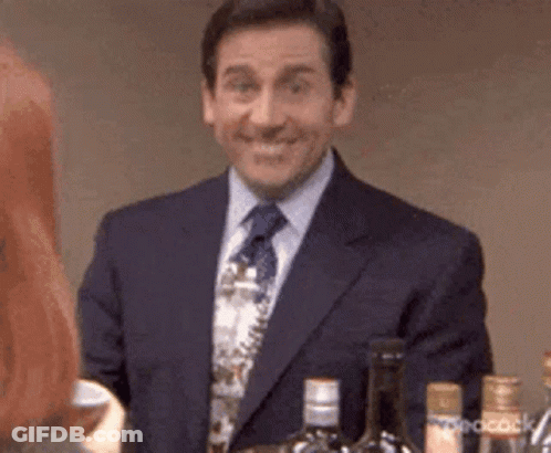 A Man In A Suit And Tie Is Standing In Front Of A Bar . GIF