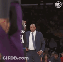 A Man In A Suit And Tie Is Standing In Front Of A Basketball Player Wearing A Jersey With The Number 21 On It GIF