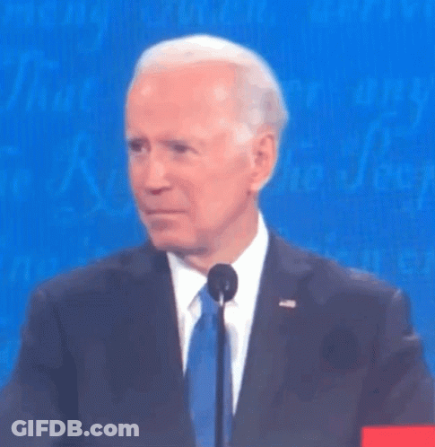 A Man In A Suit And Tie Is Standing In Front Of A Blue Background GIF