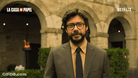A Man In A Suit And Tie Is Standing In Front Of A Building That Says La Casa De Papel On It GIF