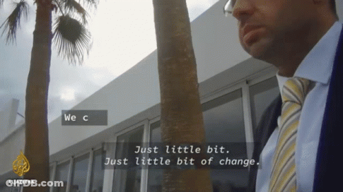 A Man In A Suit And Tie Is Standing In Front Of A Building With The Words We C Just Little Bit Just Little Bit Of Change GIF