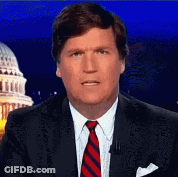 A Man In A Suit And Tie Is Standing In Front Of A Capitol Building . GIF