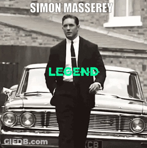 A Man In A Suit And Tie Is Standing In Front Of A Car With The Word Legend Written On It GIF