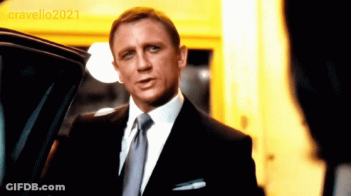 A Man In A Suit And Tie Is Standing In Front Of A Car With The Year 2021 On The Bottom Right GIF