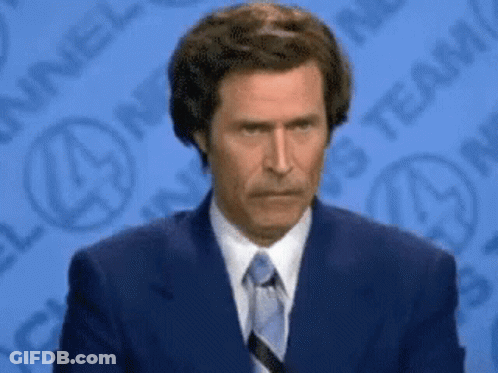 A Man In A Suit And Tie Is Standing In Front Of A Channel 4 Logo GIF