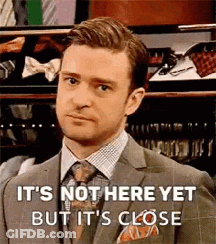 A Man In A Suit And Tie Is Standing In Front Of A Closet And Making A Funny Face . GIF