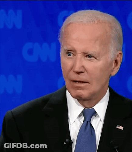 A Man In A Suit And Tie Is Standing In Front Of A Cnn Background GIF