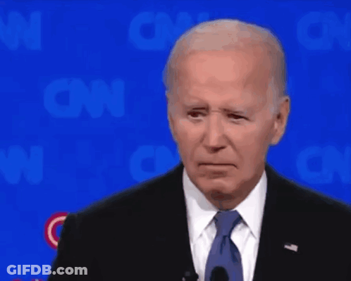 A Man In A Suit And Tie Is Standing In Front Of A Cnn Logo GIF