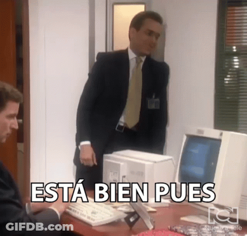 A Man In A Suit And Tie Is Standing In Front Of A Computer With The Words Esta Bien Pues Above Him GIF