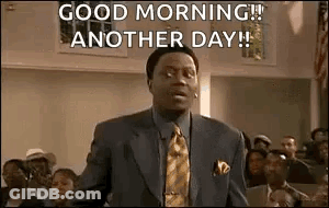 A Man In A Suit And Tie Is Standing In Front Of A Crowd And Saying `` Good Morning ! '' GIF