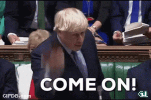 A Man In A Suit And Tie Is Standing In Front Of A Crowd And Says Come On GIF