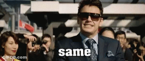 A Man In A Suit And Tie Is Standing In Front Of A Crowd Of People And Says Same . GIF
