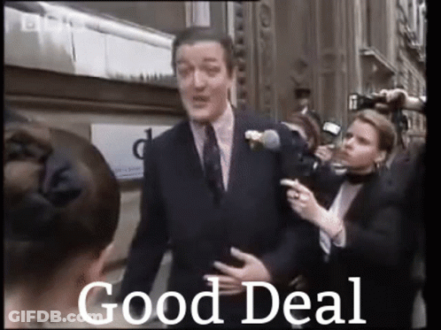 A Man In A Suit And Tie Is Standing In Front Of A Crowd Of People With The Words `` Good Deal '' Written Below Him . GIF