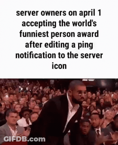 A Man In A Suit And Tie Is Standing In Front Of A Crowd Of People . GIF