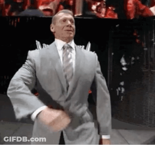 A Man In A Suit And Tie Is Standing In Front Of A Crowd . GIF
