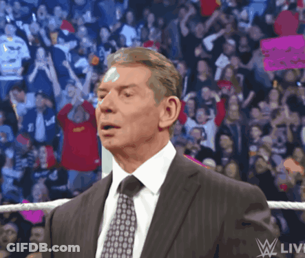A Man In A Suit And Tie Is Standing In Front Of A Crowd With A Sign That Says " I Love You " GIF