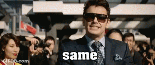 A Man In A Suit And Tie Is Standing In Front Of A Crowd With The Word Same Written On The Screen . GIF