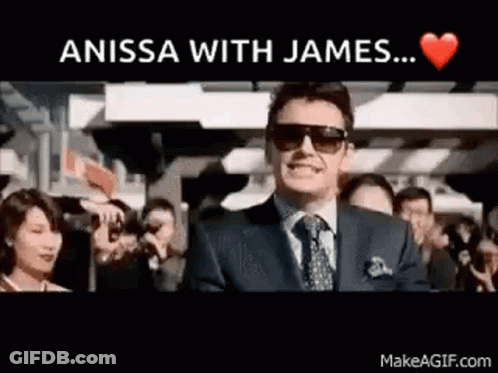 A Man In A Suit And Tie Is Standing In Front Of A Crowd With The Words " Anissa With James ... " Above Him GIF