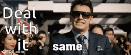 A Man In A Suit And Tie Is Standing In Front Of A Crowd With The Words Deal With It Same GIF
