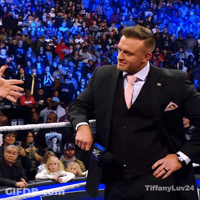 A Man In A Suit And Tie Is Standing In Front Of A Crowd With Tiffanyluv24 Written On The Bottom GIF