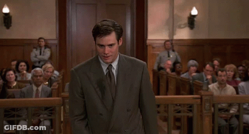 A Man In A Suit And Tie Is Standing In Front Of A Crowd GIF