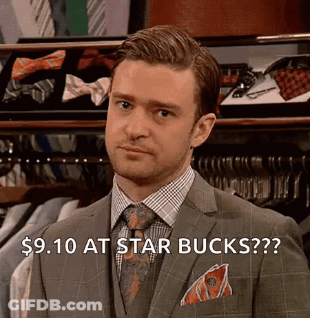 A Man In A Suit And Tie Is Standing In Front Of A Display Of Shirts And Ties . GIF