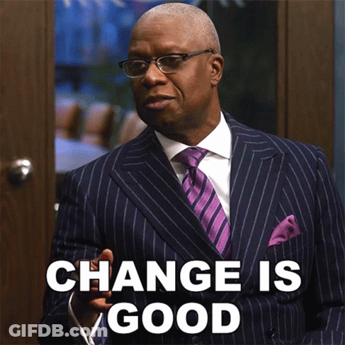 A Man In A Suit And Tie Is Standing In Front Of A Door That Says Change Is Good GIF