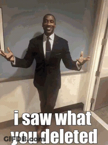A Man In A Suit And Tie Is Standing In Front Of A Door With The Words I Saw What You Deleted Written On The Bottom GIF