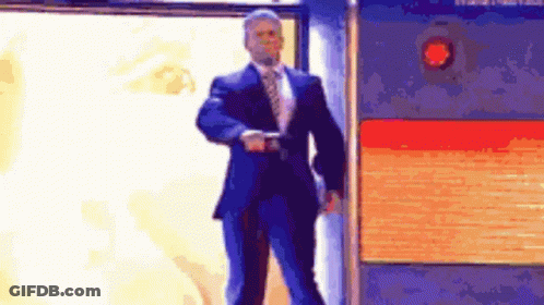 A Man In A Suit And Tie Is Standing In Front Of A Fire Alarm . GIF
