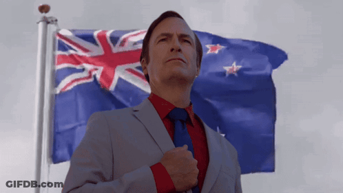 A Man In A Suit And Tie Is Standing In Front Of A Flag GIF