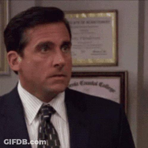 A Man In A Suit And Tie Is Standing In Front Of A Framed Diploma That Says Essential College GIF