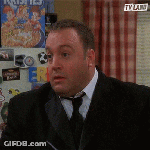 A Man In A Suit And Tie Is Standing In Front Of A Fridge With A Box Of Cereal On It . GIF