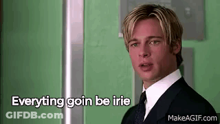 A Man In A Suit And Tie Is Standing In Front Of A Green Wall With The Words `` Everything Goin Be Irie '' . GIF