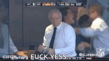 A Man In A Suit And Tie Is Standing In Front Of A Group Of People And Says Fuck Yes . GIF