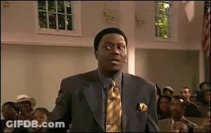 A Man In A Suit And Tie Is Standing In Front Of A Group Of People In A Church . GIF