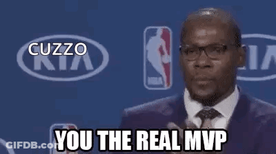 A Man In A Suit And Tie Is Standing In Front Of A Kia Logo And A Basketball Player . GIF