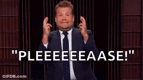 A Man In A Suit And Tie Is Standing In Front Of A Microphone And Making A Gesture With His Hands . GIF