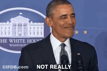 A Man In A Suit And Tie Is Standing In Front Of A Microphone And Smiling . GIF