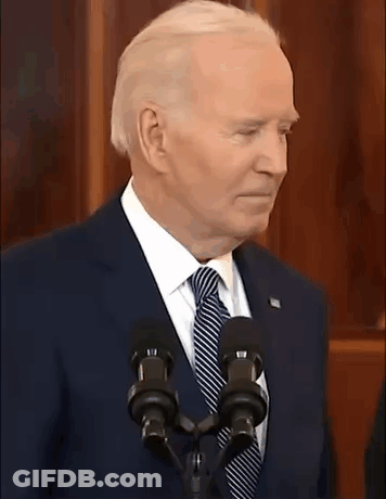 A Man In A Suit And Tie Is Standing In Front Of A Microphone With The Words Is That A Joke Written Below Him GIF