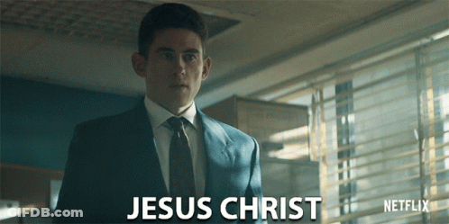 A Man In A Suit And Tie Is Standing In Front Of A Netflix Logo GIF