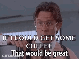 A Man In A Suit And Tie Is Standing In Front Of A Refrigerator And Talking About Coffee . GIF