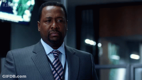 A Man In A Suit And Tie Is Standing In Front Of A Screen That Says #Jackryan GIF