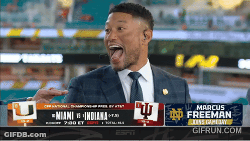 A Man In A Suit And Tie Is Standing In Front Of A Screen That Says Marcus Freeman GIF