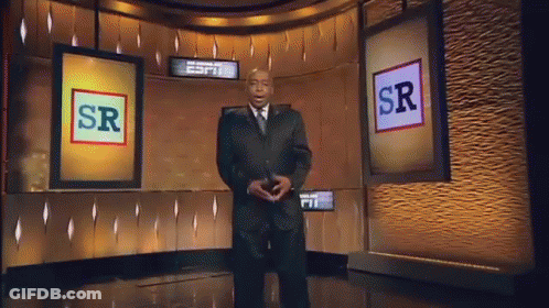 A Man In A Suit And Tie Is Standing In Front Of A Screen That Says Sr GIF