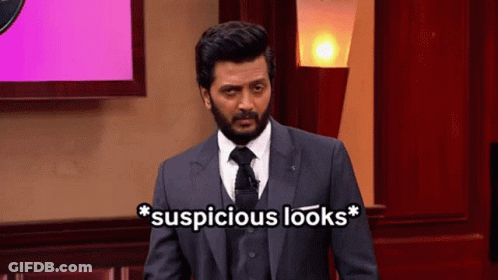 A Man In A Suit And Tie Is Standing In Front Of A Screen That Says Suspicious Looks GIF