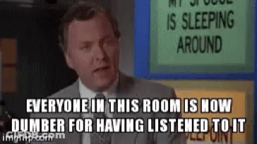 A Man In A Suit And Tie Is Standing In Front Of A Sign That Says Everyone In This Room GIF