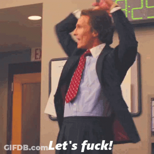 A Man In A Suit And Tie Is Standing In Front Of A Sign That Says Let 'S Fuck ! GIF