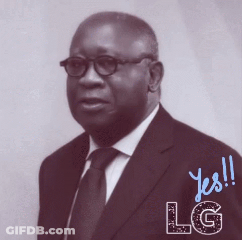 A Man In A Suit And Tie Is Standing In Front Of A Sign That Says Lg GIF