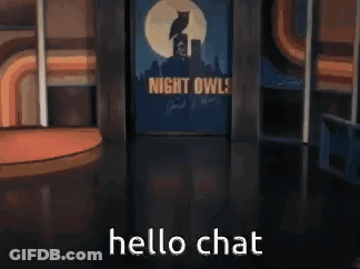 A Man In A Suit And Tie Is Standing In Front Of A Sign That Says Night Owl . GIF