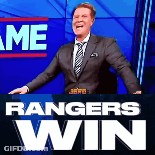 A Man In A Suit And Tie Is Standing In Front Of A Sign That Says " Rangers Win " GIF